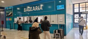 Pasajeros en la ventanilla de venta de billetes de Baleària