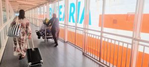Unas pasajeras cruzan la pasarela de embarque