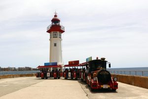 El trenecito turístico, junto al Faro Rojo